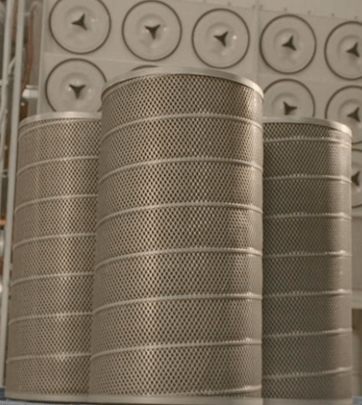 Dust collector replacement filters displayed in front of an industrial dust collector.